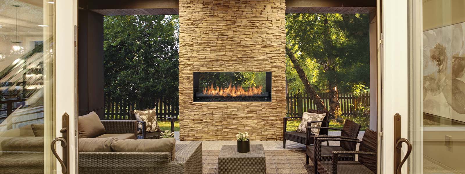 Dreamy outdoor covered patio with stone fireplace